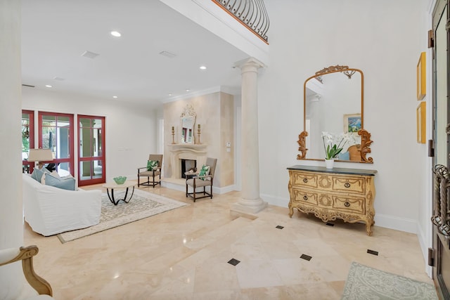 living area featuring recessed lighting, decorative columns, baseboards, and a fireplace with raised hearth