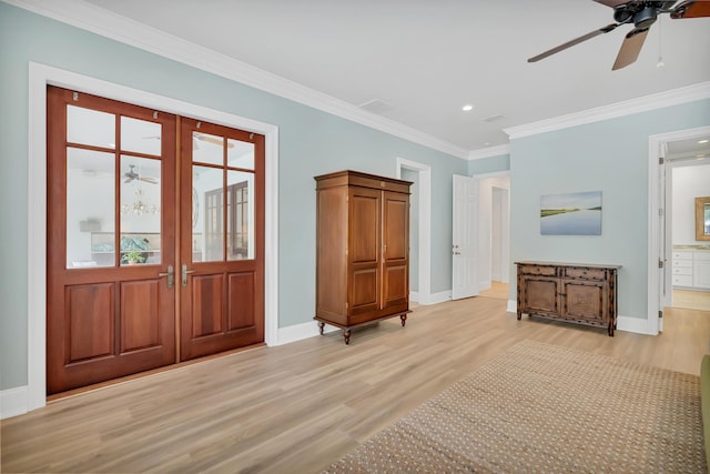 interior space featuring ceiling fan, baseboards, light wood finished floors, and ornamental molding