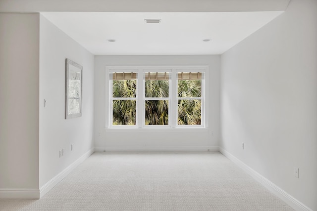 carpeted empty room with visible vents and baseboards