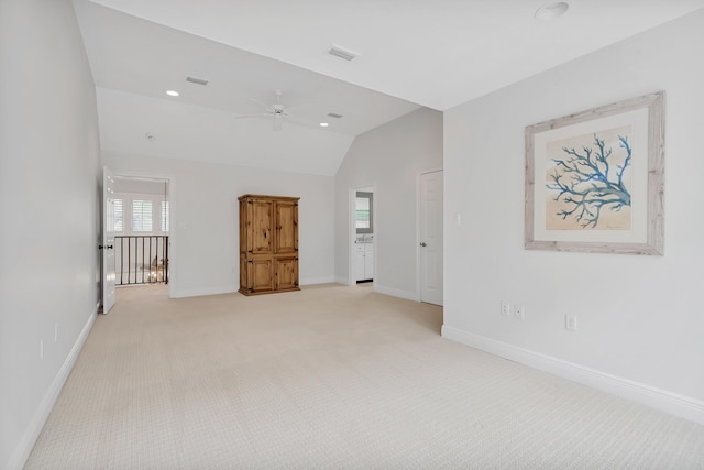 empty room with visible vents, baseboards, light colored carpet, and lofted ceiling