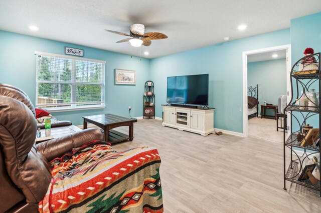 living room with light hardwood / wood-style flooring and ceiling fan