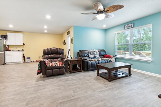 living room with ceiling fan and light hardwood / wood-style flooring