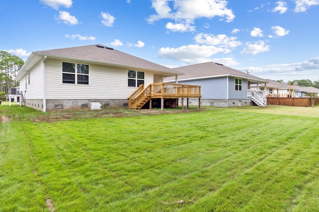 back of property with a lawn and a deck