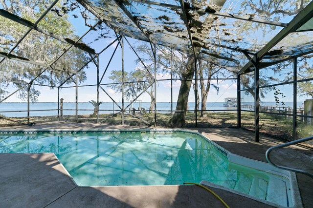 view of swimming pool with a lanai and a water view