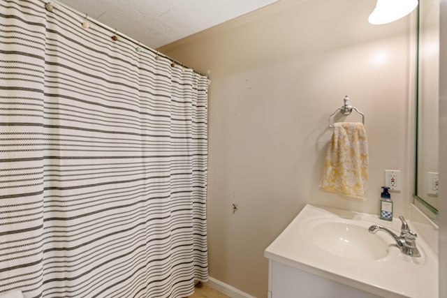 bathroom featuring walk in shower, vanity, and ornamental molding