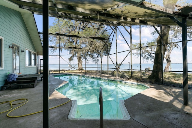 view of swimming pool with a patio area, a water view, and glass enclosure