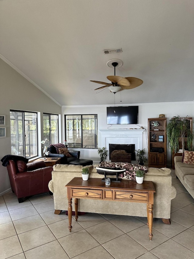 living room featuring ceiling fan, light tile patterned flooring, crown molding, and vaulted ceiling