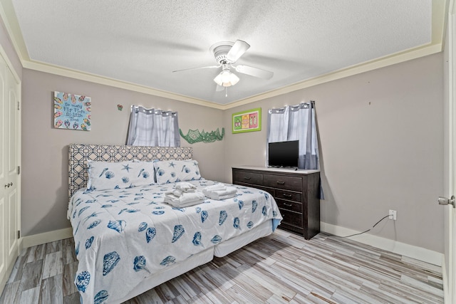 bedroom featuring ornamental molding, light hardwood / wood-style flooring, ceiling fan, and a textured ceiling