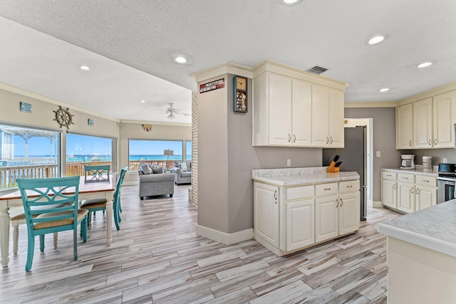 kitchen with ornamental molding, a healthy amount of sunlight, ceiling fan, and range