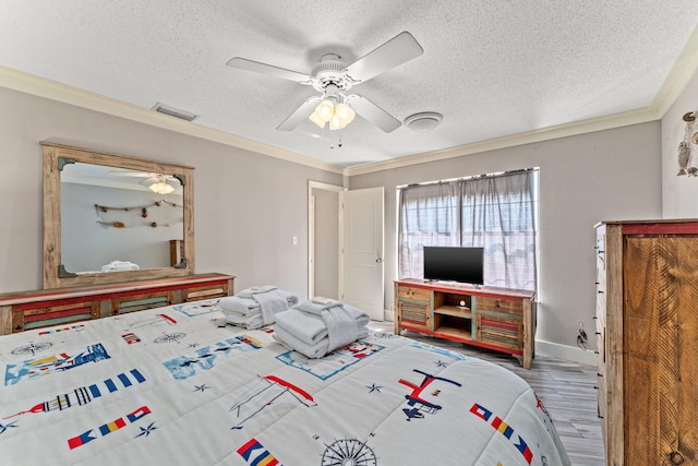 bedroom with wood-type flooring, a textured ceiling, ceiling fan, and crown molding