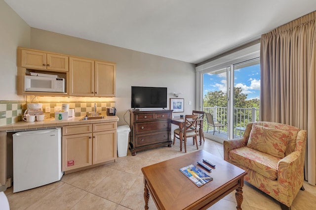 kitchen featuring light brown cabinets, backsplash, light tile floors, sink, and tile countertops