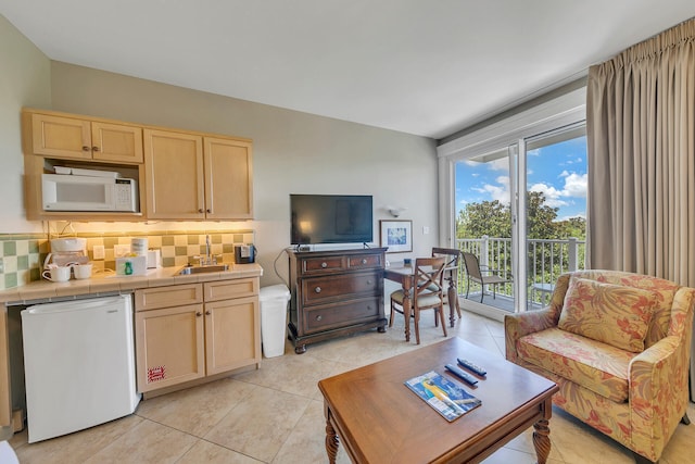 kitchen featuring tile counters, white appliances, backsplash, and light tile floors