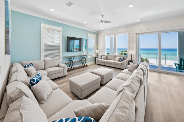 living room with ornamental molding, ceiling fan, a water view, and light wood-type flooring