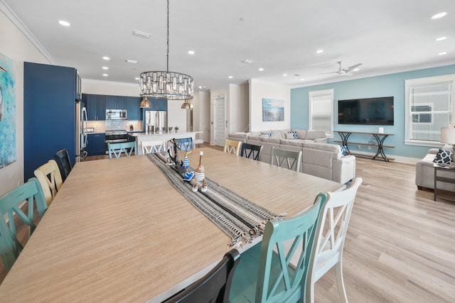 dining area featuring ornamental molding, ceiling fan, and light wood-type flooring