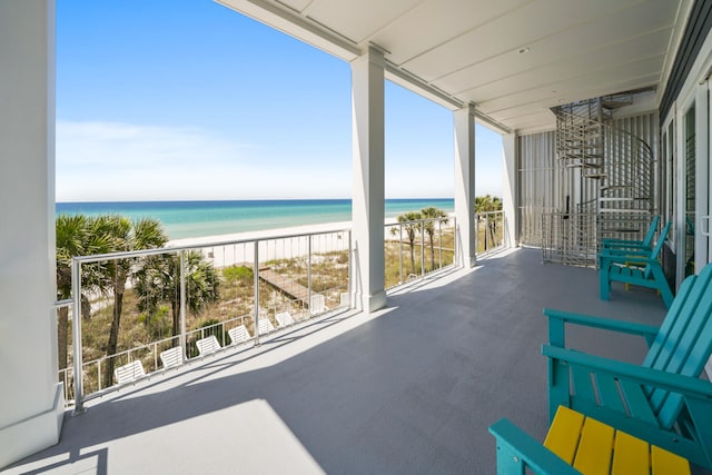 balcony featuring a water view and a view of the beach