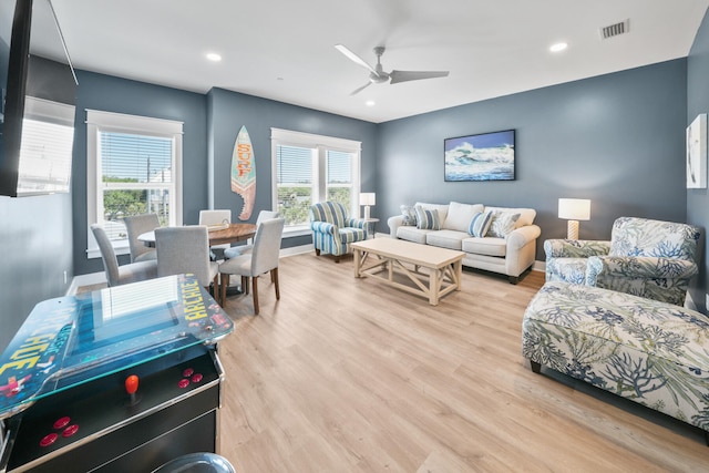 living room with light hardwood / wood-style floors and ceiling fan