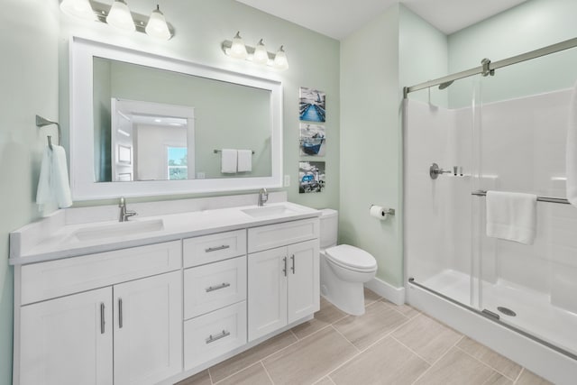 bathroom with dual bowl vanity, a shower with shower door, toilet, and tile floors