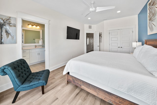 bedroom with a closet, light hardwood / wood-style floors, ceiling fan, and ensuite bathroom