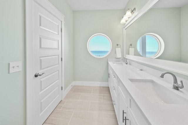 bathroom with a healthy amount of sunlight, tile floors, and dual bowl vanity