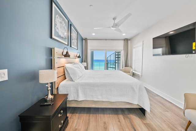 bedroom with ceiling fan, a water view, light wood-type flooring, and access to exterior