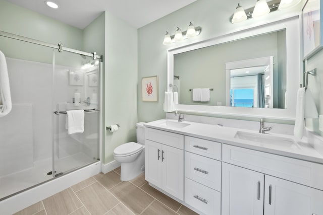 bathroom featuring double sink vanity, toilet, an enclosed shower, and tile floors