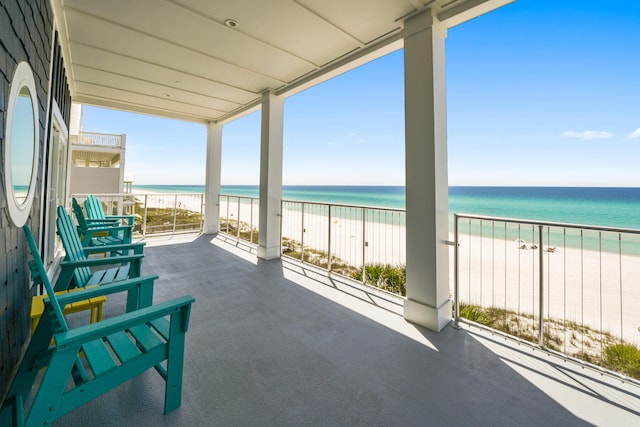 balcony featuring a water view and a view of the beach