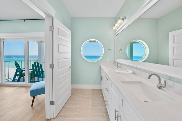 bathroom with dual bowl vanity, tile floors, and a water view