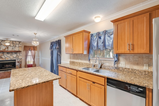 kitchen with plenty of natural light, sink, dishwasher, and a stone fireplace