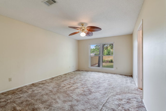 carpeted empty room featuring ceiling fan and a textured ceiling