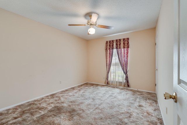 carpeted spare room with a textured ceiling and ceiling fan