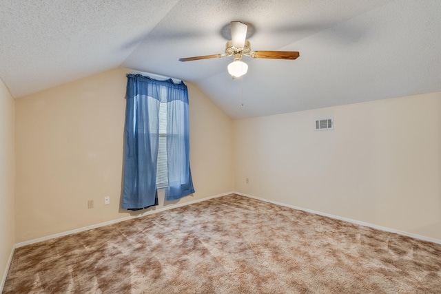 bonus room featuring lofted ceiling, ceiling fan, carpet flooring, and a textured ceiling