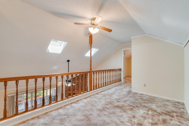 bonus room with lofted ceiling with skylight, ceiling fan, carpet flooring, and a textured ceiling