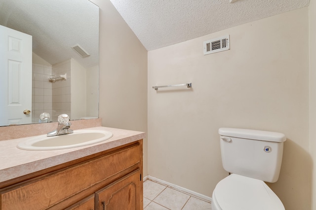 bathroom with a textured ceiling, vanity, toilet, and tile flooring