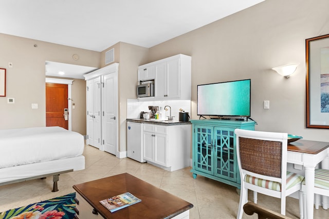 bedroom with sink and light tile floors