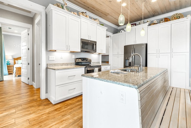 kitchen with crown molding, light hardwood / wood-style floors, a center island with sink, white cabinets, and appliances with stainless steel finishes