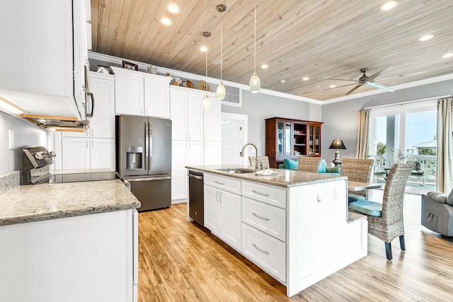 kitchen with pendant lighting, stainless steel appliances, white cabinetry, and an island with sink