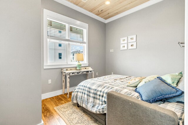 bedroom featuring hardwood / wood-style flooring, wooden ceiling, and crown molding