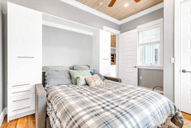 bedroom featuring light hardwood / wood-style floors, ceiling fan, crown molding, and wood ceiling