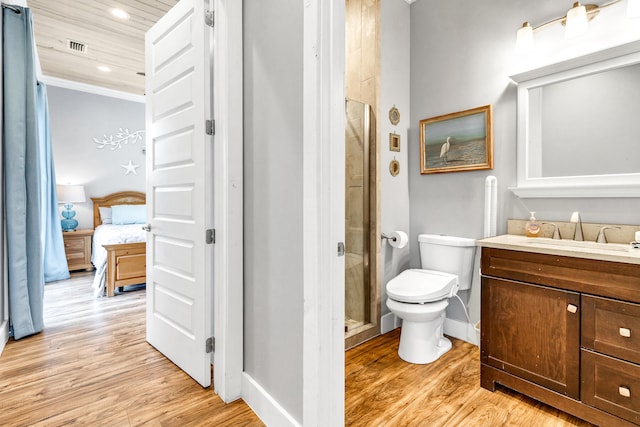 bathroom featuring toilet, vanity, an enclosed shower, and hardwood / wood-style flooring