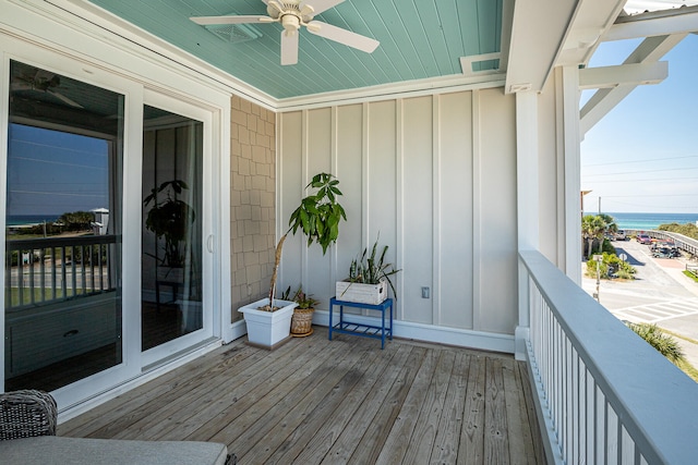 wooden terrace featuring ceiling fan and a water view