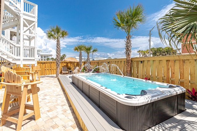 view of swimming pool with an outdoor hot tub