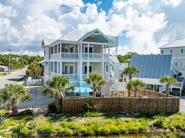 1235 Allen Loop Dr, Santa Rosa Beach, FL 32459 - rear view of property with a fenced front yard, a balcony, covered porch, and a metal roof