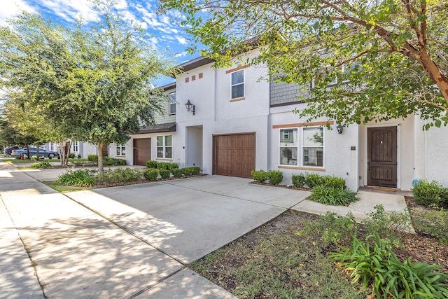 view of front of property with driveway, a garage, and stucco siding