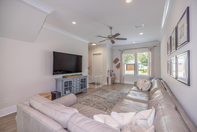 living area featuring visible vents, crown molding, baseboards, and wood finished floors