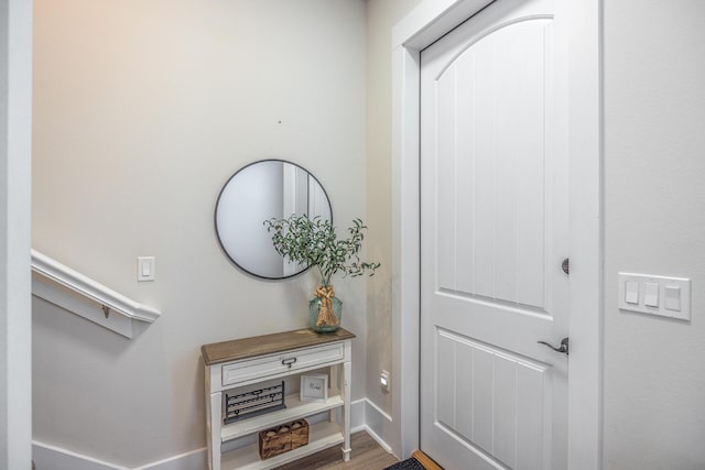 doorway with baseboards and wood finished floors