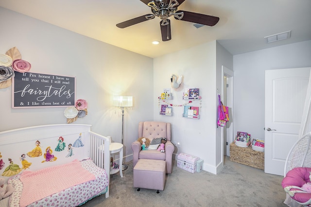 bedroom featuring ceiling fan, visible vents, baseboards, a nursery area, and carpet