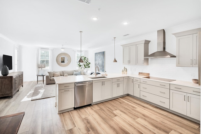 kitchen with kitchen peninsula, dishwasher, wall chimney exhaust hood, light wood-type flooring, and sink