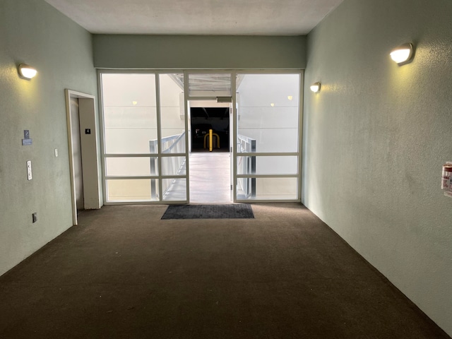 unfurnished room with dark colored carpet and elevator