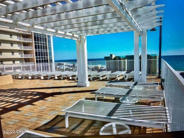 view of terrace with a water view, a balcony, and a pergola