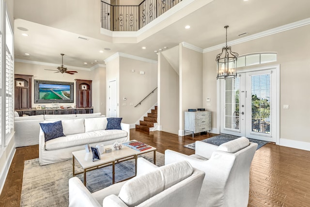 24 Norriego Rd, Destin, FL 32541 - living room with ceiling fan with notable chandelier, a towering ceiling, dark hardwood / wood-style flooring, and ornamental molding